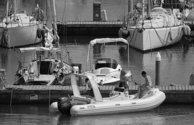 İtalya, Sicilya, Akdeniz, Marina di Ragusa (Ragusa ili); 7 Temmuz 2024, limandaki kauçuk bir teknede insanlar - EDITORIAL