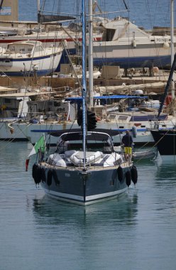 İtalya, Sicilya, Akdeniz, Marina di Ragusa (Ragusa ili); 7 Temmuz 2024, limanda bir yelkenli ve lüks yatlarda erkekler - EDITORIAL