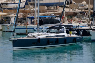 İtalya, Sicilya, Akdeniz, Marina di Ragusa (Ragusa ili); 7 Temmuz 2024, limanda bir yelkenli ve lüks yatlarda erkekler - EDITORIAL