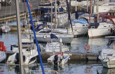 İtalya, Sicilya, Akdeniz, Marina di Ragusa (Ragusa ili); 7 Temmuz 2024, limandaki bir yelkenli teknesinde insanlar - EDITORIAL