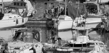 İtalya, Sicilya, Akdeniz, Marina di Ragusa (Ragusa Eyaleti); 11 Temmuz 2024, limandaki insanlar, motorlu tekneler ve lüks yatlar - EDITORIAL