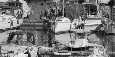 İtalya, Sicilya, Akdeniz, Marina di Ragusa (Ragusa Eyaleti); 11 Temmuz 2024, limandaki insanlar, motorlu tekneler ve lüks yatlar - EDITORIAL