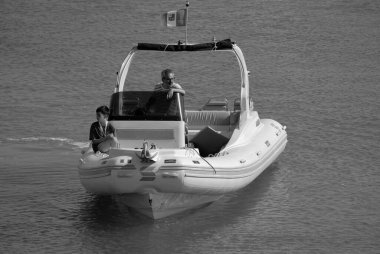 İtalya, Sicilya, Akdeniz, Marina di Ragusa (Ragusa Eyaleti); 12 Temmuz 2024, limandaki büyük bir kauçuk teknede insanlar - EDITORIAL