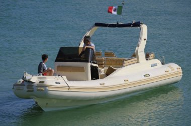 İtalya, Sicilya, Akdeniz, Marina di Ragusa (Ragusa Eyaleti); 12 Temmuz 2024, limandaki büyük bir kauçuk teknede insanlar - EDITORIAL