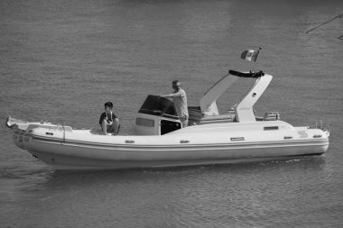 İtalya, Sicilya, Akdeniz, Marina di Ragusa (Ragusa Eyaleti); 12 Temmuz 2024, limandaki büyük bir kauçuk teknede insanlar - EDITORIAL