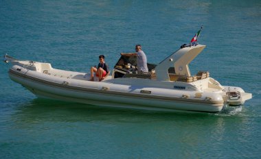 İtalya, Sicilya, Akdeniz, Marina di Ragusa (Ragusa Eyaleti); 12 Temmuz 2024, limandaki büyük bir kauçuk teknede insanlar - EDITORIAL