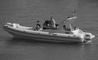 İtalya, Sicilya, Akdeniz, Marina di Ragusa (Ragusa Eyaleti); 12 Temmuz 2024, limandaki büyük bir kauçuk teknede insanlar - EDITORIAL