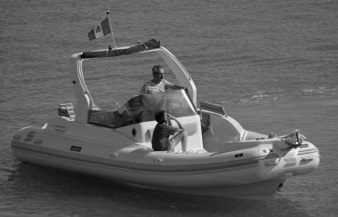 İtalya, Sicilya, Akdeniz, Marina di Ragusa (Ragusa Eyaleti); 12 Temmuz 2024, limandaki büyük bir kauçuk teknede insanlar - EDITORIAL