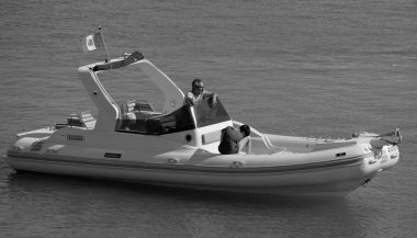 İtalya, Sicilya, Akdeniz, Marina di Ragusa (Ragusa Eyaleti); 12 Temmuz 2024, limandaki büyük bir kauçuk teknede insanlar - EDITORIAL