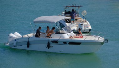 İtalya, Sicilya, Akdeniz, Marina di Ragusa (Ragusa Eyaleti); 13 Temmuz 2024, limandaki lüks yatlarda yaşayan insanlar - EDITORIAL