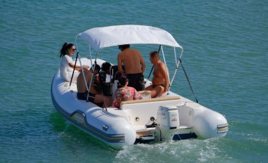 İtalya, Sicilya, Akdeniz, Marina di Ragusa (Ragusa Eyaleti); 13 Temmuz 2024, limandaki kauçuk bir teknede insanlar - EDITORIAL