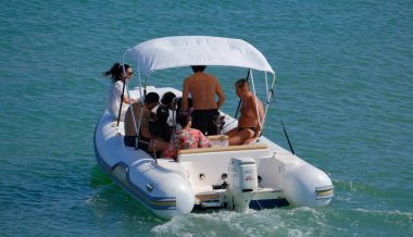 İtalya, Sicilya, Akdeniz, Marina di Ragusa (Ragusa Eyaleti); 13 Temmuz 2024, limandaki kauçuk bir teknede insanlar - EDITORIAL