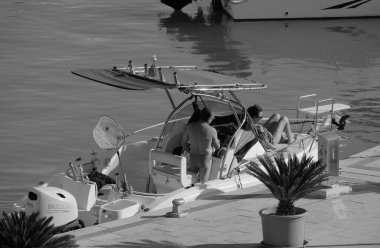 İtalya, Sicilya, Akdeniz, Marina di Ragusa (Ragusa ili); 13 Temmuz 2024, limandaki balıkçı teknesinde bir çift - EDITORIAL