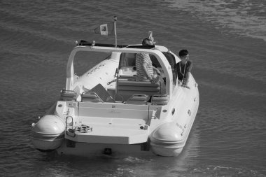 İtalya, Sicilya, Akdeniz, Marina di Ragusa (Ragusa Eyaleti); 12 Temmuz 2024, limandaki büyük bir kauçuk teknede insanlar - EDITORIAL