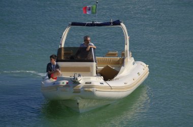 İtalya, Sicilya, Akdeniz, Marina di Ragusa (Ragusa Eyaleti); 12 Temmuz 2024, limandaki büyük bir kauçuk teknede insanlar - EDITORIAL