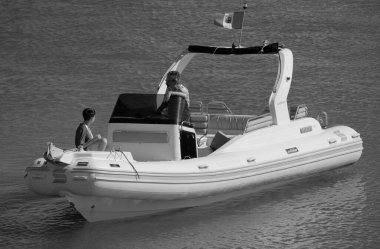 İtalya, Sicilya, Akdeniz, Marina di Ragusa (Ragusa Eyaleti); 12 Temmuz 2024, limandaki büyük bir kauçuk teknede insanlar - EDITORIAL