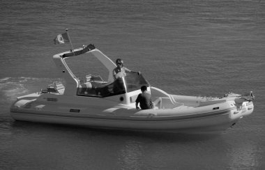 İtalya, Sicilya, Akdeniz, Marina di Ragusa (Ragusa Eyaleti); 12 Temmuz 2024, limandaki büyük bir kauçuk teknede insanlar - EDITORIAL