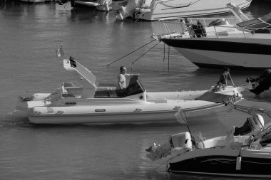 İtalya, Sicilya, Akdeniz, Marina di Ragusa (Ragusa Eyaleti); 12 Temmuz 2024, limandaki büyük bir kauçuk teknede insanlar - EDITORIAL