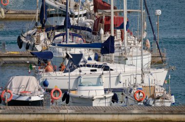 İtalya, Sicilya, Akdeniz, Marina di Ragusa (Ragusa ili); 14 Temmuz 2024, limandaki bir yelkenli teknesinde çift - EDITORIAL