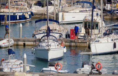 İtalya, Sicilya, Akdeniz, Marina di Ragusa (Ragusa ili); 14 Temmuz 2024, limandaki bir yelkenli teknesinde çift - EDITORIAL