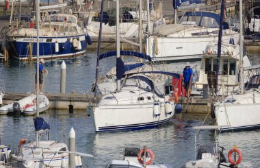 İtalya, Sicilya, Akdeniz, Marina di Ragusa (Ragusa ili); 14 Temmuz 2024, limandaki bir yelkenli teknesinde çift - EDITORIAL