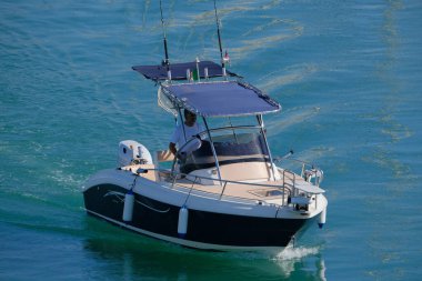 İtalya, Sicilya, Akdeniz, Marina di Ragusa (Ragusa Eyaleti); 15 Temmuz 2024, limandaki bir motorlu teknede balıkçı - EDITORIAL