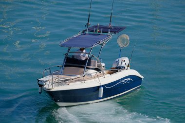 İtalya, Sicilya, Akdeniz, Marina di Ragusa (Ragusa Eyaleti); 15 Temmuz 2024, limandaki bir motorlu teknede balıkçı - EDITORIAL