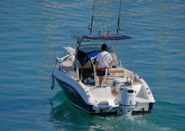 İtalya, Sicilya, Akdeniz, Marina di Ragusa (Ragusa Eyaleti); 15 Temmuz 2024, limandaki bir motorlu teknede balıkçı - EDITORIAL