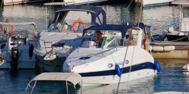 İtalya, Sicilya, Akdeniz, Marina di Ragusa (Ragusa Eyaleti); 16 Temmuz 2024, limanda lüks bir yatta insanlar - EDITORIAL