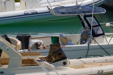 İtalya, Sicilya, Akdeniz, Marina di Ragusa (Ragusa Eyaleti); 17 Temmuz 2024, limandaki bir motorlu teknede balıkçı - EDITORIAL