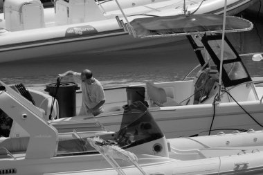 İtalya, Sicilya, Akdeniz, Marina di Ragusa (Ragusa Eyaleti); 17 Temmuz 2024, limandaki bir motorlu teknede balıkçı - EDITORIAL