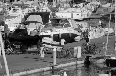 İtalya, Sicilya, Akdeniz, Marina di Ragusa (Ragusa ili); 17 Temmuz 2024, limandaki insanlar ve lüks yatlar - EDITORIAL