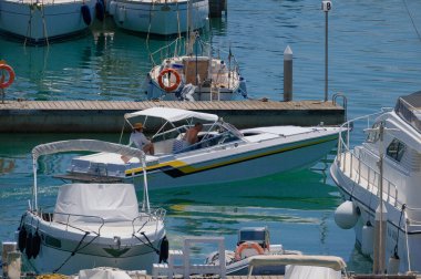 İtalya, Sicilya, Akdeniz, Marina di Ragusa (Ragusa ili); 18 Temmuz 2024, limanda lüks bir yatta çift - EDITORIAL