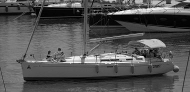 İtalya, Sicilya, Akdeniz, Marina di Ragusa (Ragusa ili); 18 Temmuz 2024, limandaki bir yelkenli teknesinde insanlar - EDITORIAL