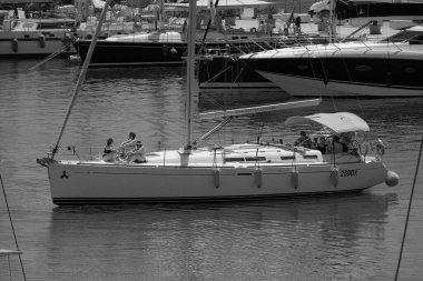 İtalya, Sicilya, Akdeniz, Marina di Ragusa (Ragusa ili); 18 Temmuz 2024, limandaki bir yelkenli teknesinde insanlar - EDITORIAL