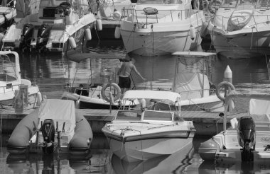 İtalya, Sicilya, Akdeniz, Marina di Ragusa (Ragusa Eyaleti); 19 Temmuz 2024, limandaki bir motorlu teknede balıkçı - EDITORIAL