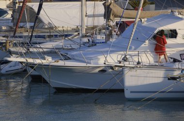 İtalya, Sicilya, Akdeniz, Marina di Ragusa (Ragusa Eyaleti); 21 Temmuz 2024, limanda lüks bir yatta bir kadın - EDITORIAL