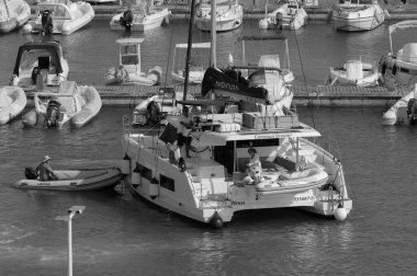 İtalya, Sicilya, Akdeniz, Marina di Ragusa (Ragusa ili); 24 Temmuz 2024, limanda bir katamaran yelkenli teknesinde çift - EDITORIAL