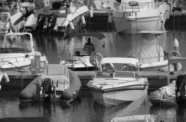 İtalya, Sicilya, Akdeniz, Marina di Ragusa (Ragusa Eyaleti); 26 Temmuz 2024, limandaki bir motorlu teknede adam - EDITORIAL