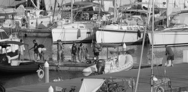 İtalya, Sicilya, Akdeniz, Marina di Ragusa (Ragusa ili); 27 Temmuz 2024, limandaki insanlar, motorlu tekneler ve lüks yatlar - EDITORIAL