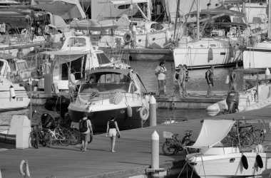 İtalya, Sicilya, Akdeniz, Marina di Ragusa (Ragusa ili); 27 Temmuz 2024, limandaki insanlar, motorlu tekneler ve lüks yatlar - EDITORIAL