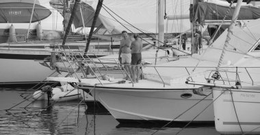 İtalya, Sicilya, Akdeniz, Marina di Ragusa (Ragusa ili); 27 Temmuz 2024, limanda lüks bir yatta erkekler - EDITORIAL