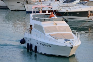 İtalya, Sicilya, Akdeniz, Marina di Ragusa (Ragusa ili); 27 Temmuz 2024, limanda lüks bir yatta çift - EDITORIAL