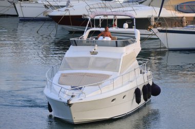 İtalya, Sicilya, Akdeniz, Marina di Ragusa (Ragusa Eyaleti); 27 Temmuz 2024, limanda lüks bir yatta bir adam - EDITORIAL