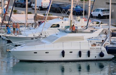 İtalya, Sicilya, Akdeniz, Marina di Ragusa (Ragusa ili); 27 Temmuz 2024, limanda lüks bir yatta çift - EDITORIAL