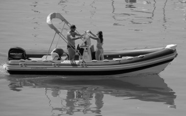 İtalya, Sicilya, Akdeniz, Marina di Ragusa (Ragusa ili); 28 Temmuz 2024, limanda bir kauçuk teknede çift - EDITORIAL