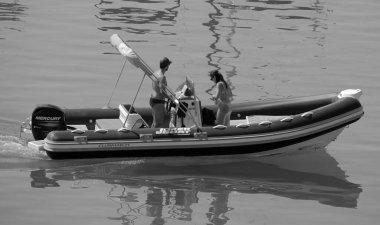 İtalya, Sicilya, Akdeniz, Marina di Ragusa (Ragusa ili); 28 Temmuz 2024, limanda bir kauçuk teknede çift - EDITORIAL