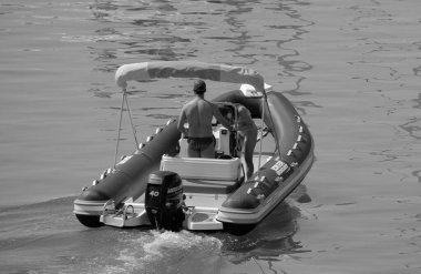 İtalya, Sicilya, Akdeniz, Marina di Ragusa (Ragusa ili); 28 Temmuz 2024, limanda bir kauçuk teknede çift - EDITORIAL