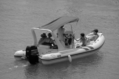 İtalya, Sicilya, Akdeniz, Marina di Ragusa (Ragusa Eyaleti); 28 Temmuz 2024, limandaki kauçuk bir teknede insanlar - EDITORIAL