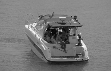 İtalya, Sicilya, Akdeniz, Marina di Ragusa (Ragusa Eyaleti); 28 Temmuz 2024, limanda lüks bir yatta insanlar - EDITORIAL